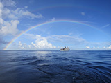 The NOAA Ship Hi'ialakai somewhere under the rainbow at Rose Atoll Marine National Monument, American Samoa.  Credit: NOAA